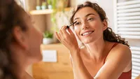 Beautiful woman applying mascara