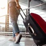 Traveler with suitcase in airport concept.Young girl walking with carrying luggage and passenger for tour travel booking ticket flight at international vacation time in holiday rest and relaxation.