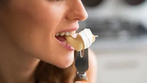 Vrouw pakt na het avondeten een stukje kaas in plaats van een zoet dessert aan tafel.