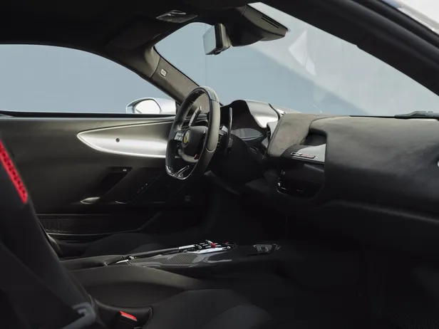 Interieur van de Ferrari CZ26 met zwart dashboard, carbon middenconsole en sportstuur.