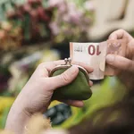 Close-up of woman paying for Flowers with a 10 Euro Bill 