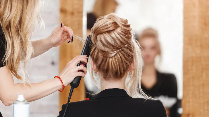 business woman lady boss in beauty salon making hairdress and looking to the mirror