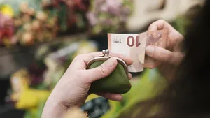 Close-up of woman paying for Flowers with a 10 Euro Bill 