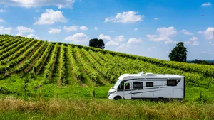 Moderne camper rijdend langs een wijngaard