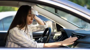 Vrouw die in hete auto zit.