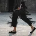 Foto van vrouw met ballerina schoenen en stijlvolle pantalon tijdens Fashion Week.