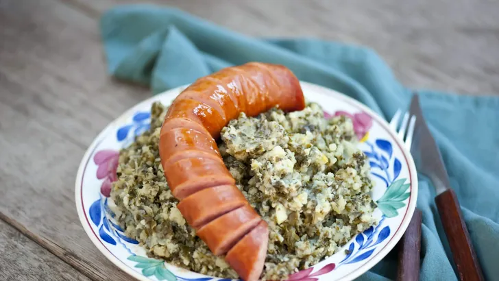 Rustic cuisine with “Boerenkool spamppot” or smoked sausage cabbage, traditional Dutch food. With a typical Dutch plate. stamppot boerenkool .