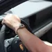 Man met een Rolex rijdt in een Ferrari