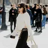Street style foto van vrouw in zwart-witte Louis Vuitton outfit tijdens Parijs Fashion Week 2026