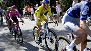 Demi Vollering in de gele trui fietst geconcentreerd op kop van het peloton tijdens de Tour de France Femmes, gevolgd door andere wielrensters.