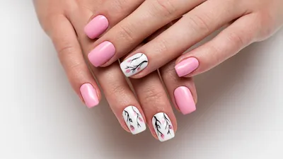 Vrouw laat handen met roze en bloemige manicure zien