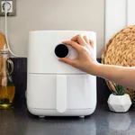 Woman cooking with modern Air fryer