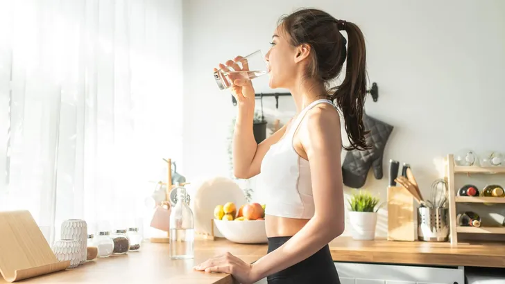Asian beautiful woman in sportswear drink water after exercise a