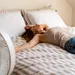 Vrouw op bed met ventilator tijdens zomernachten
