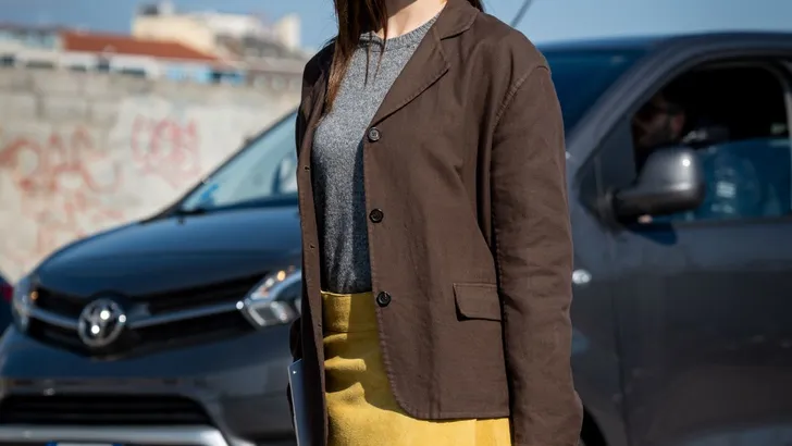 Vrouw in stijlvolle outfit met botergele accenten.