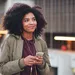 vrouw die podcast luistert met telefoon in handen en oordopjes in