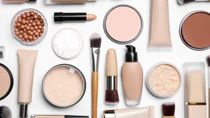 Face powders and other makeup products on white background, flat lay