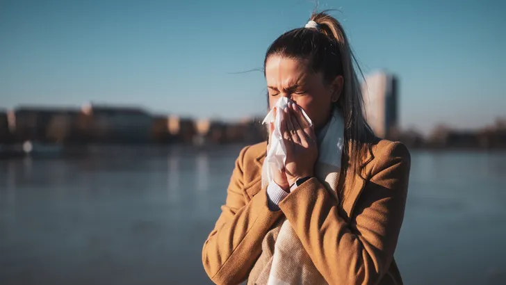vrouw moet niezen in de zon