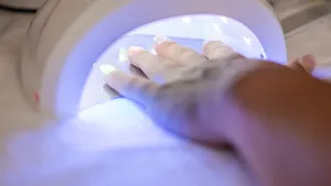 Female hand in the lamp for manicure