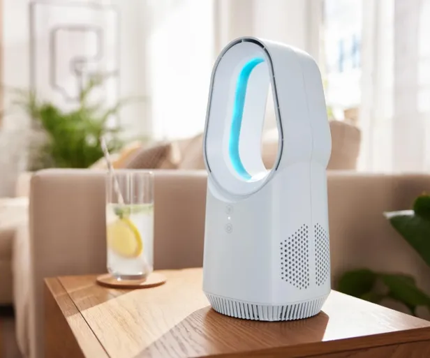 Een tafelventilator op bijzettafel met drankje ernaast