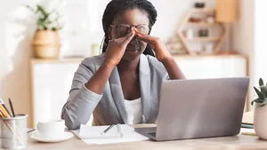 Overworked Black Businesswoman Massaging Nosebridge At Workplace Having Eyesight Problem