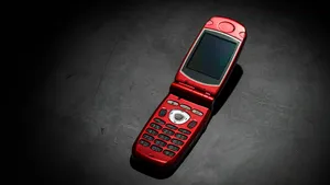 Old used cell phone on dark background