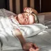 Vrouw in bed rekt haar arm uit