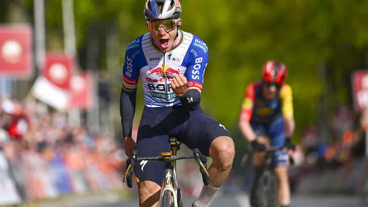 Remco Evenepoel viert zijn overwinning in de sprint van de Amstel Gold Race met een krachtig zegegebaar en een schreeuw van vreugde