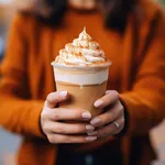 Woman Holding Frothy Pumpkin Spice Latte Outdoors