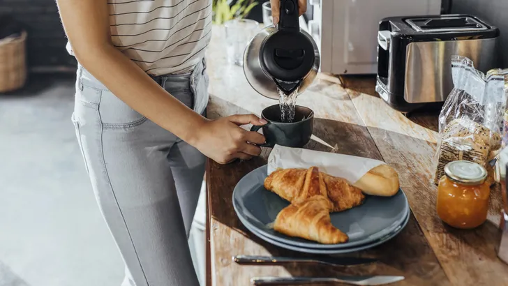 Anonymous Woman Pouring Hot Water to Make Tea for Breakfast in the Kitchen, a Close Up