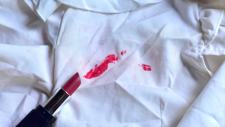 Stains of lipstick or makeup on white clothes or stains on clothes from everyday accidents. Concept of cleaning stains on clothes or cleaning the house. Selected focus