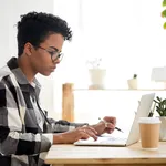 African american young woman using laptop working or studying online