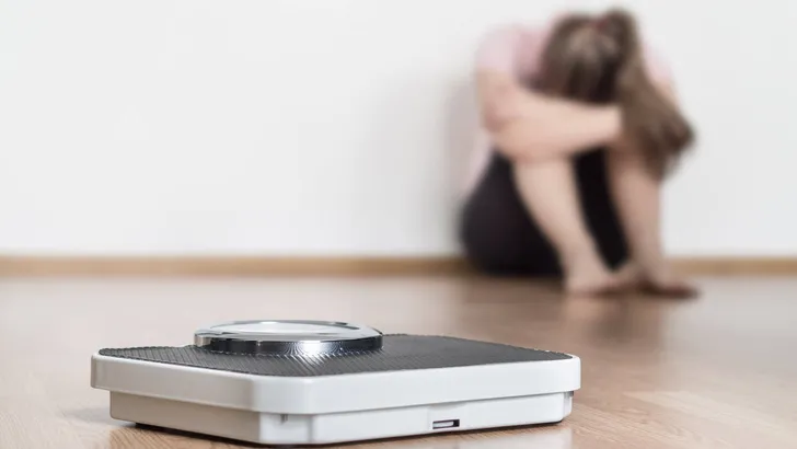 Weight loss fail concept. Scale and depressed, frustrated and sa
