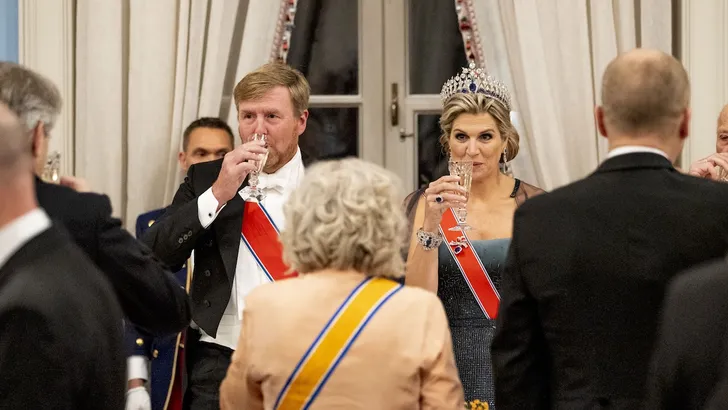 Foto van koning Willem-Alexander en koningin Máxima met champagne bij staatsbanket in Noorwegen.