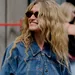 Vrouw met blonde krullen en zonnebril draagt spijkerjas - denim set H&M