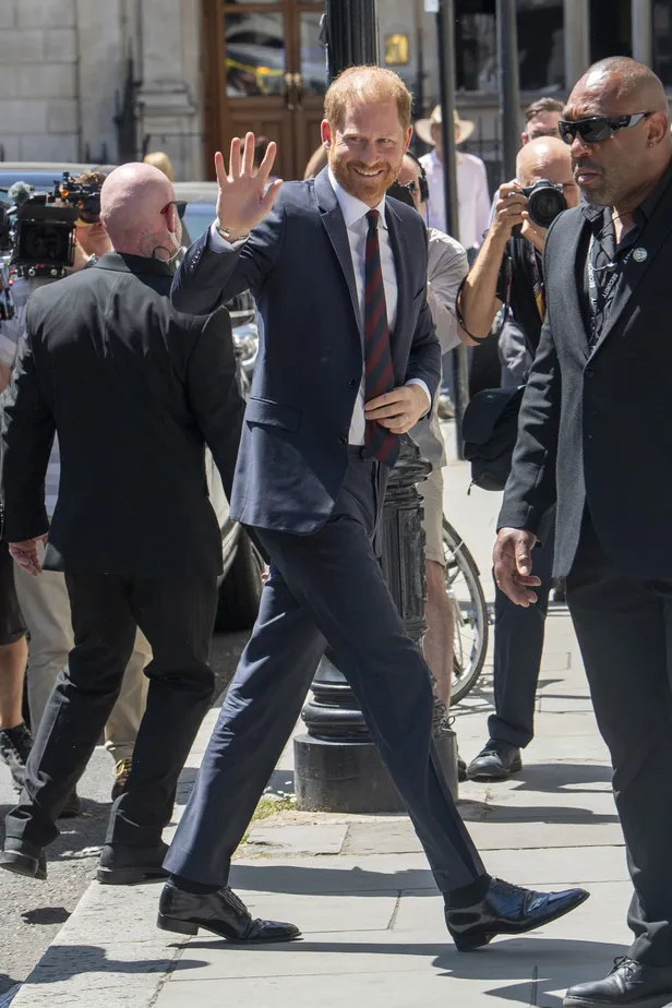 Prins Harry in pak, arriveert bij de rechtszaal voor de privacyrechtszaak. 