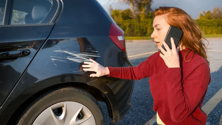 Woman calling insurance service after car crash
