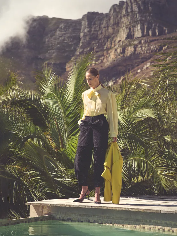 Gele blouse: Zadig & Voltaire | Jas: Balenciaga | Zwarte broek: Dolce & Gabbana 