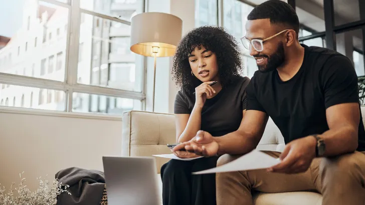 Finance, account and black couple with laptop on sofa doing online banking. Bills, budget and black man and woman with documents, paperwork and computer doing banking, payment and check bank account