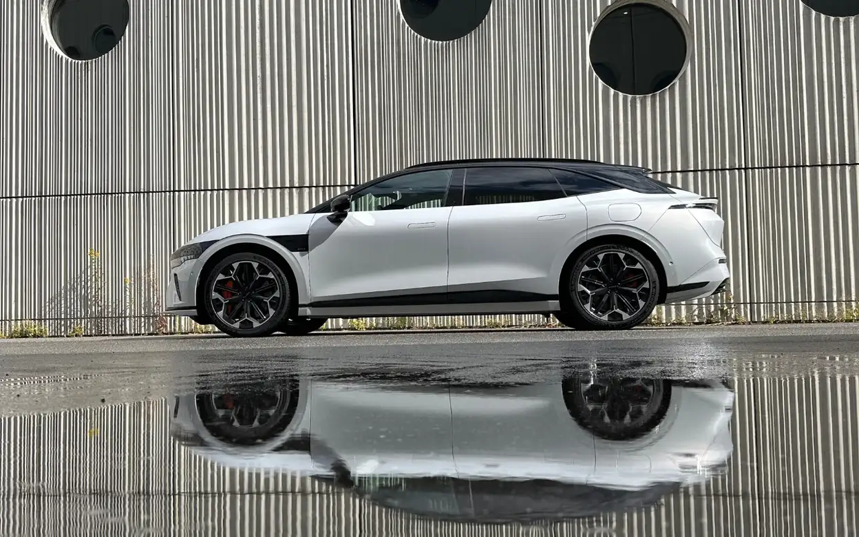 Zeekr 7GT Privilege AWD in zijaanzicht met weerspiegeling in het natte wegdek