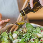 Closeup of hands pouring olive or sunflower oil