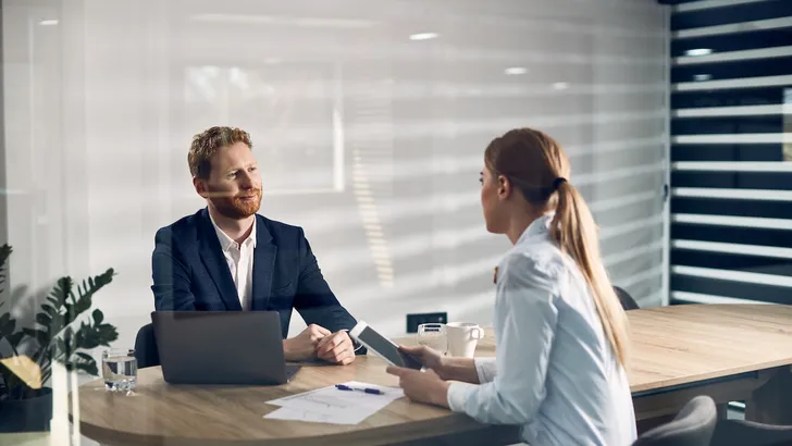 Smiling businessman  having meeting with female colleague while working in the office.
