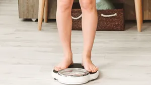 vrouw staat op de weegschaal en is aangekomen