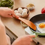 Woman Frying Eggs for Breakfast