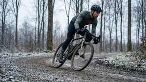 Man op gravelbike neemt met perfecte techniek een snelle bocht op een onverhard pad