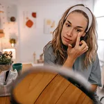 Woman rubbing cream under eyes