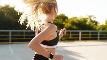 Afbeelding van een aantrekkelijke vrouw in sportkleding die buiten hardloopt.