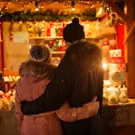 happy senior couple hugging at christmas market