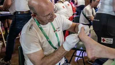 Wandelaar krijgt hulp van EHBO voor blaren door wandelen tijdens Vierdaagse.