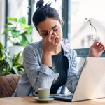 Stressed business woman working from home on laptop looking worr